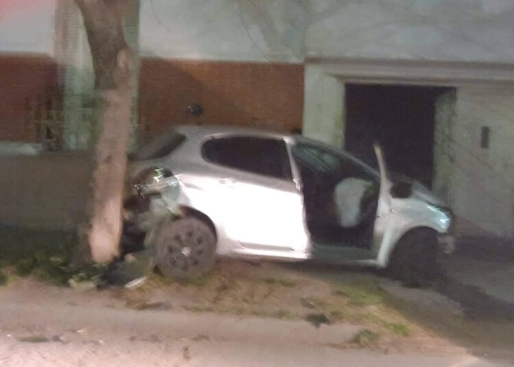 Un auto termino incrustado en un portón sobre la vereda