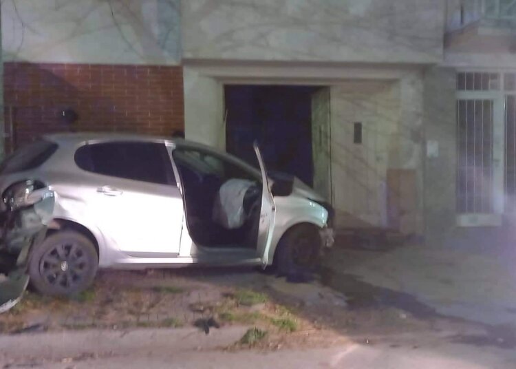 Un auto termino incrustado en un portón sobre la vereda